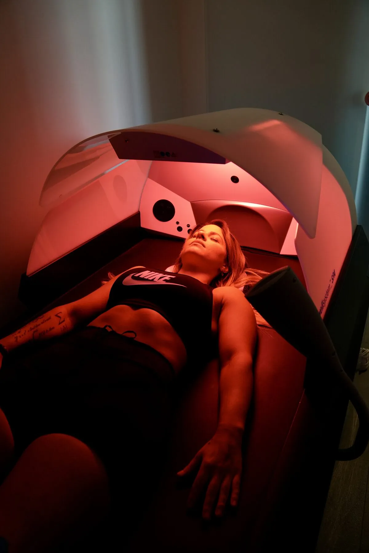 Frau liegt in der Wellsystem-Massageliege mit rotem Licht